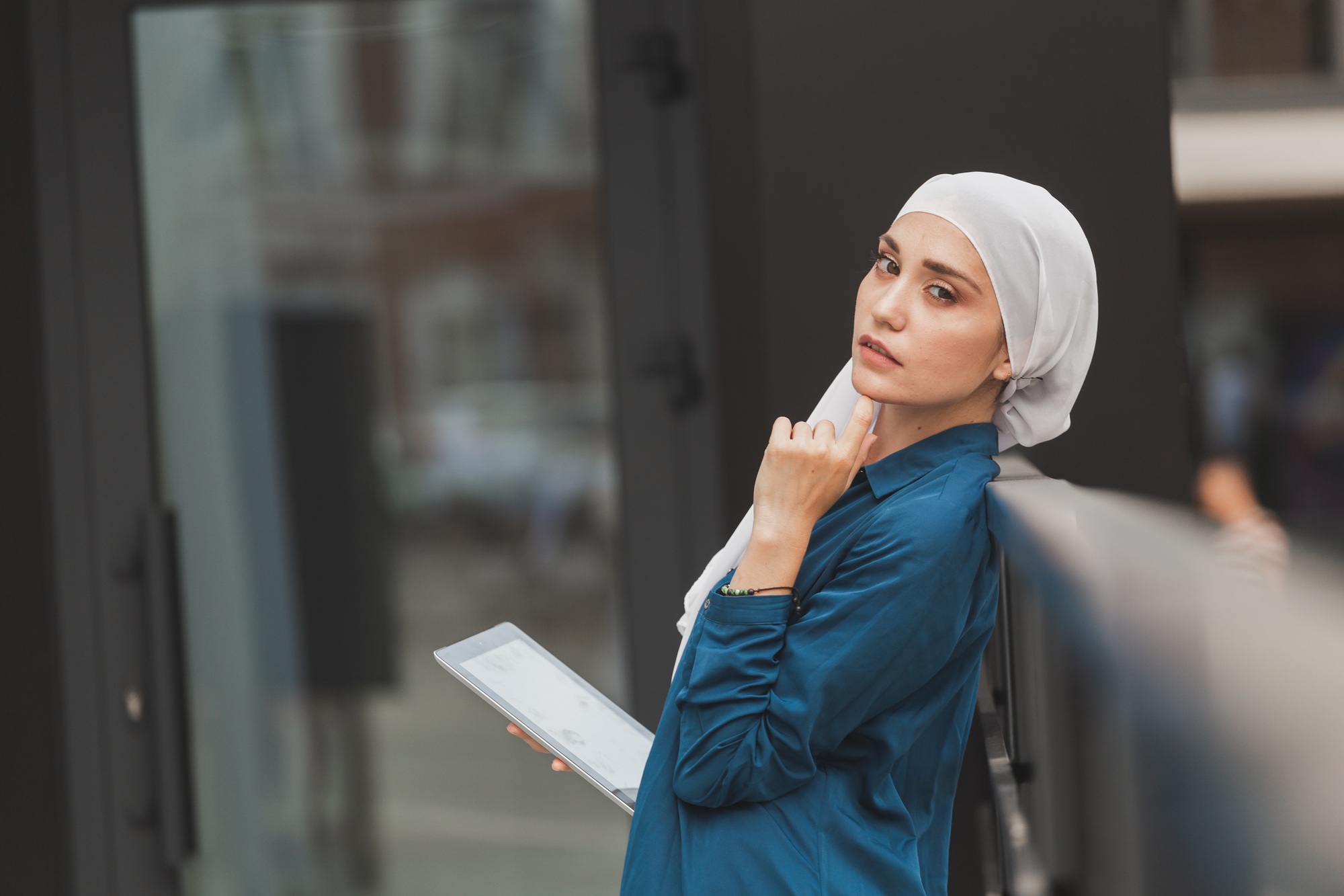 Young asian muslim woman in head scarf smile with mobile tablet and copy space